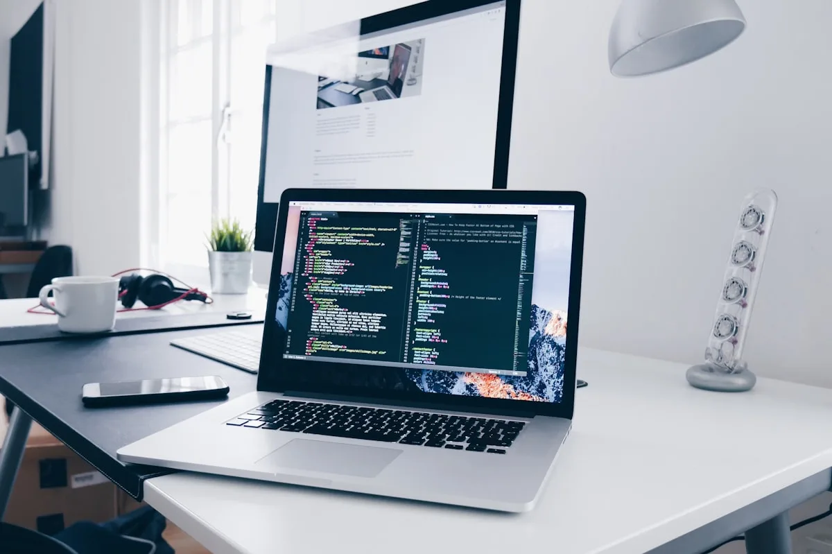 Detalle de laptop con código — el trabajo como credencial