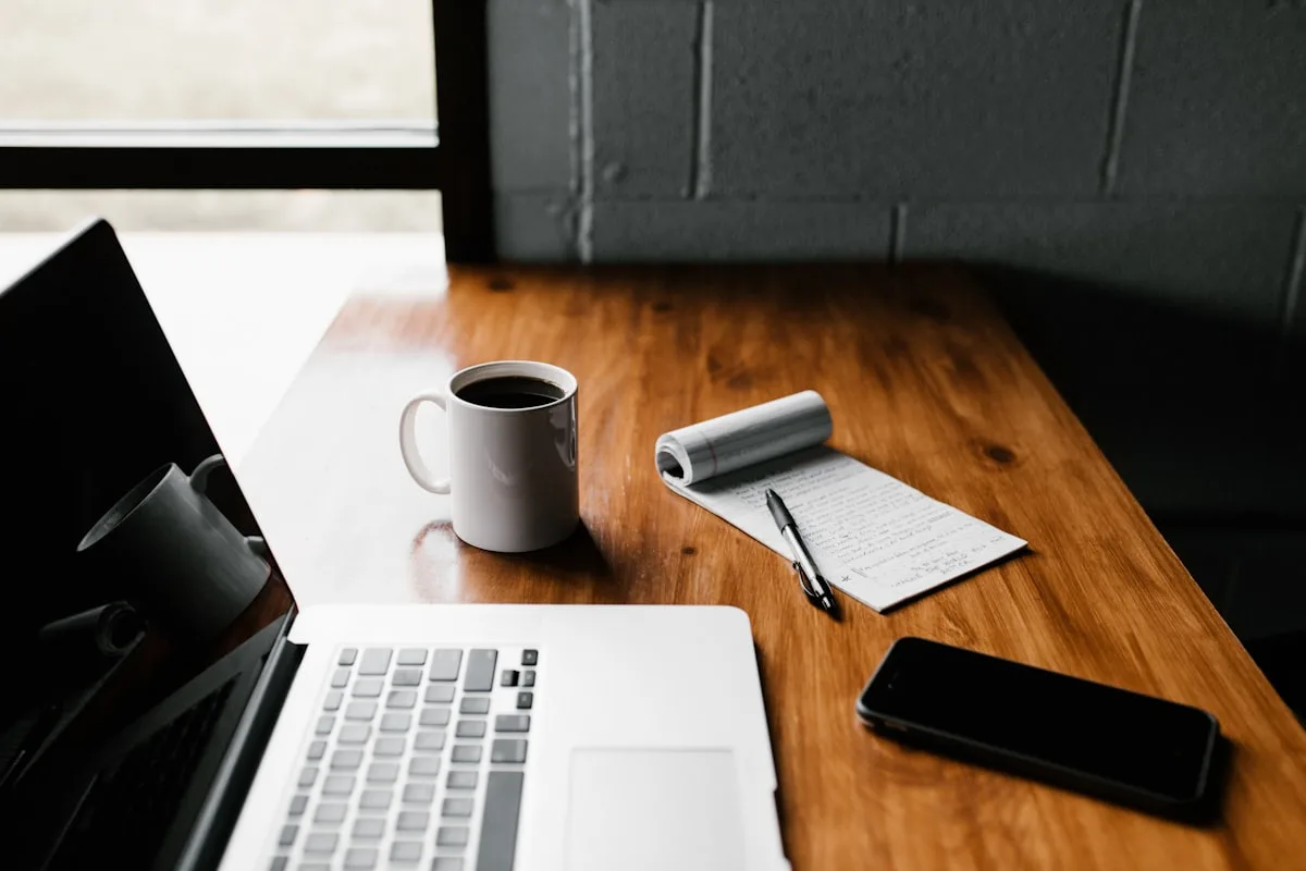 Espacio de trabajo calmo con café y libreta sobre mesa de madera
