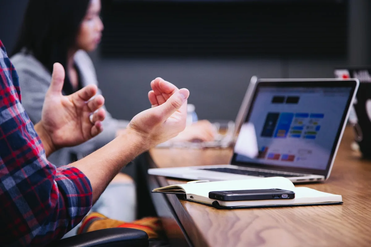 Equipo colaborando alrededor de una mesa con laptops — trabajo por postulaciones